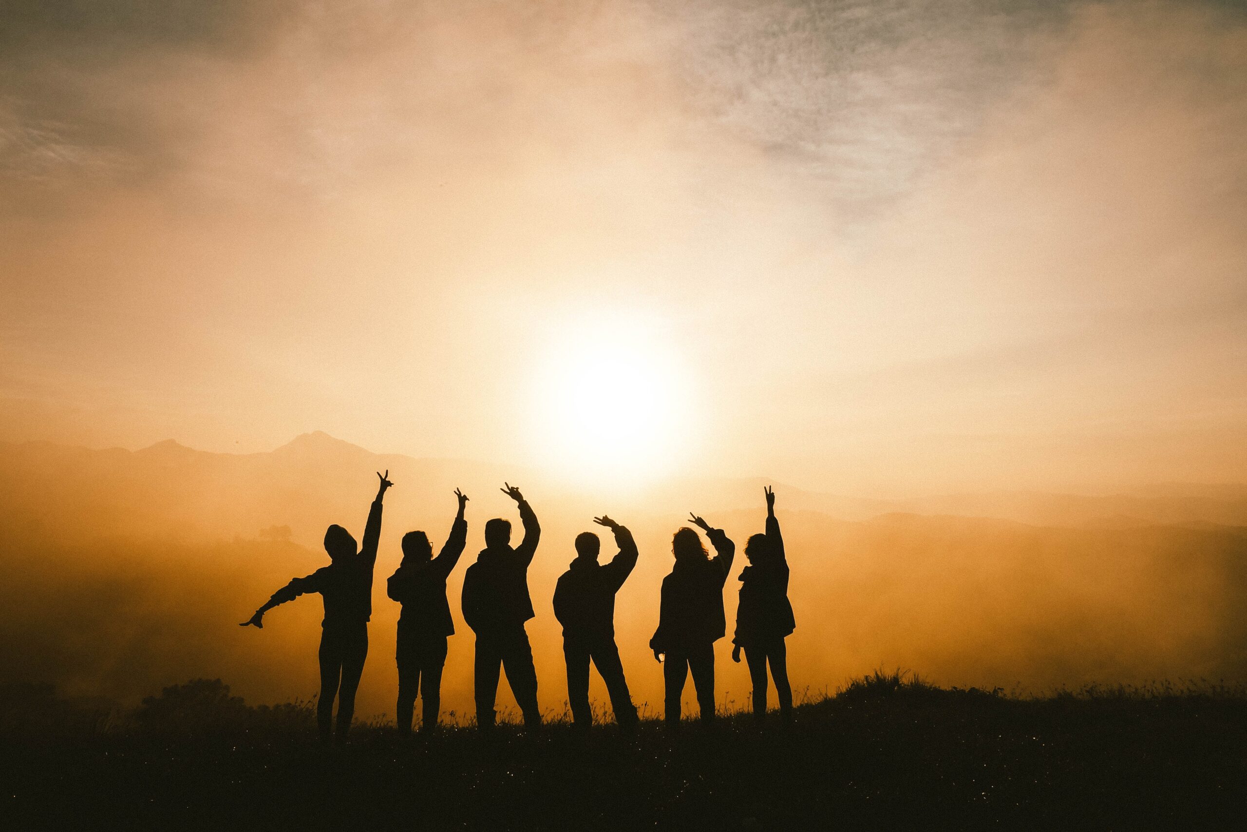 Group standing on hill looking at sunrise