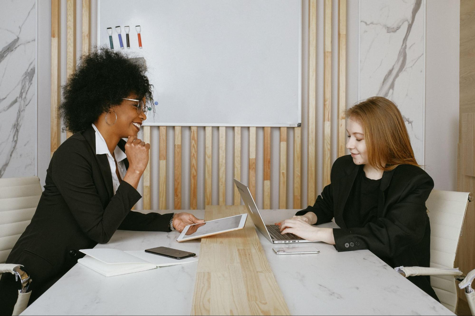 Two people sitting together in office meeting room