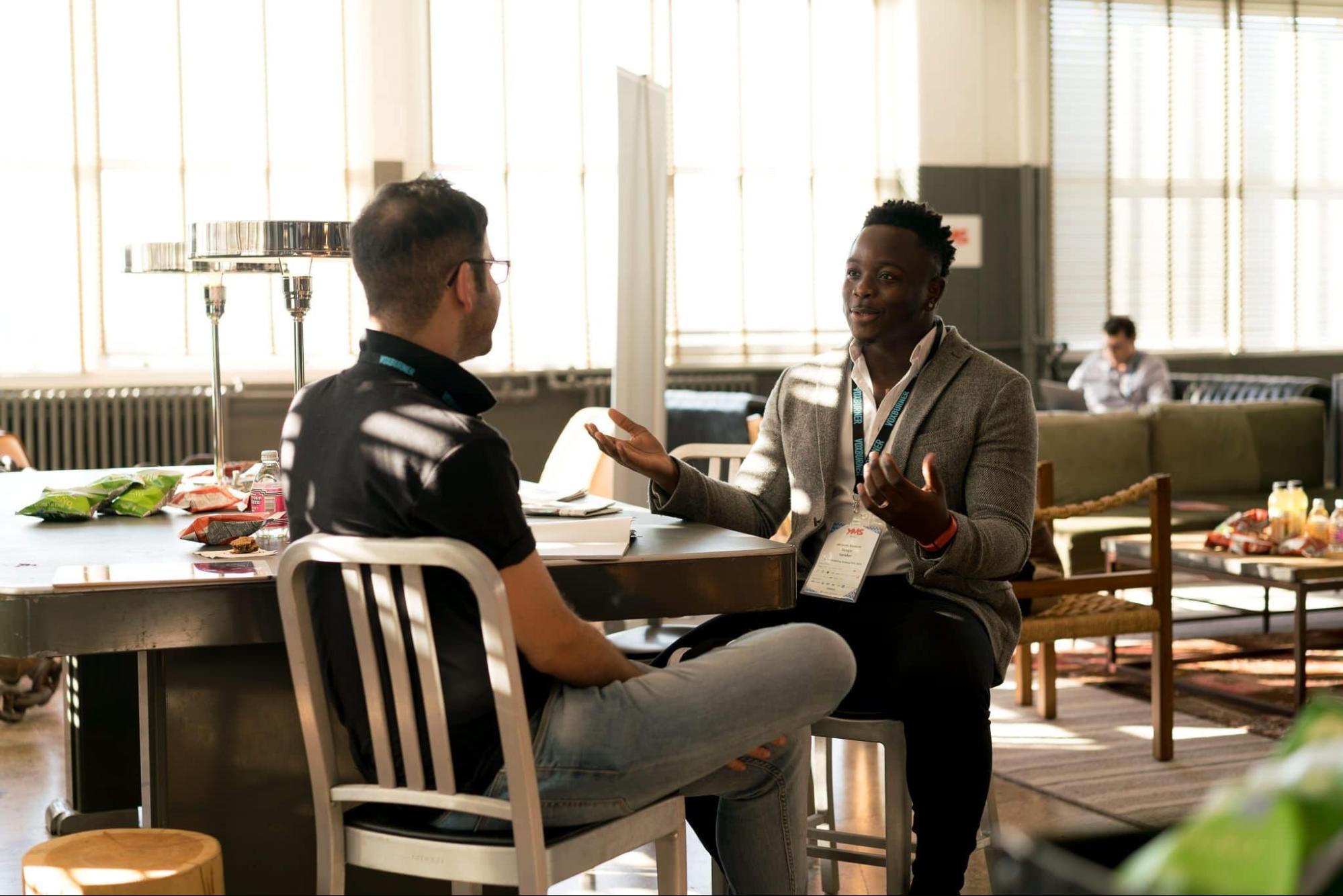 Two coworkers talking at table