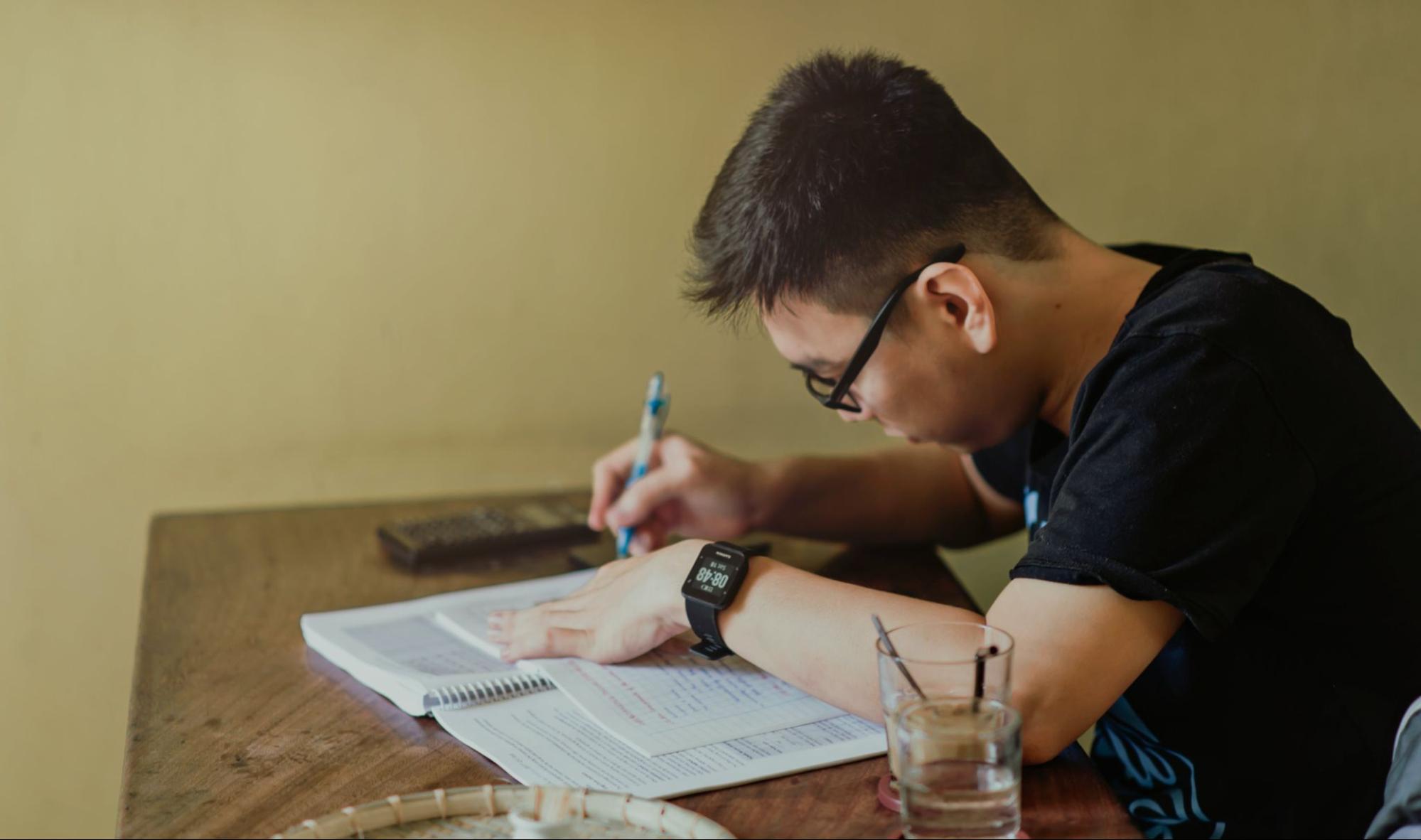 Man sitting at table jotting notes