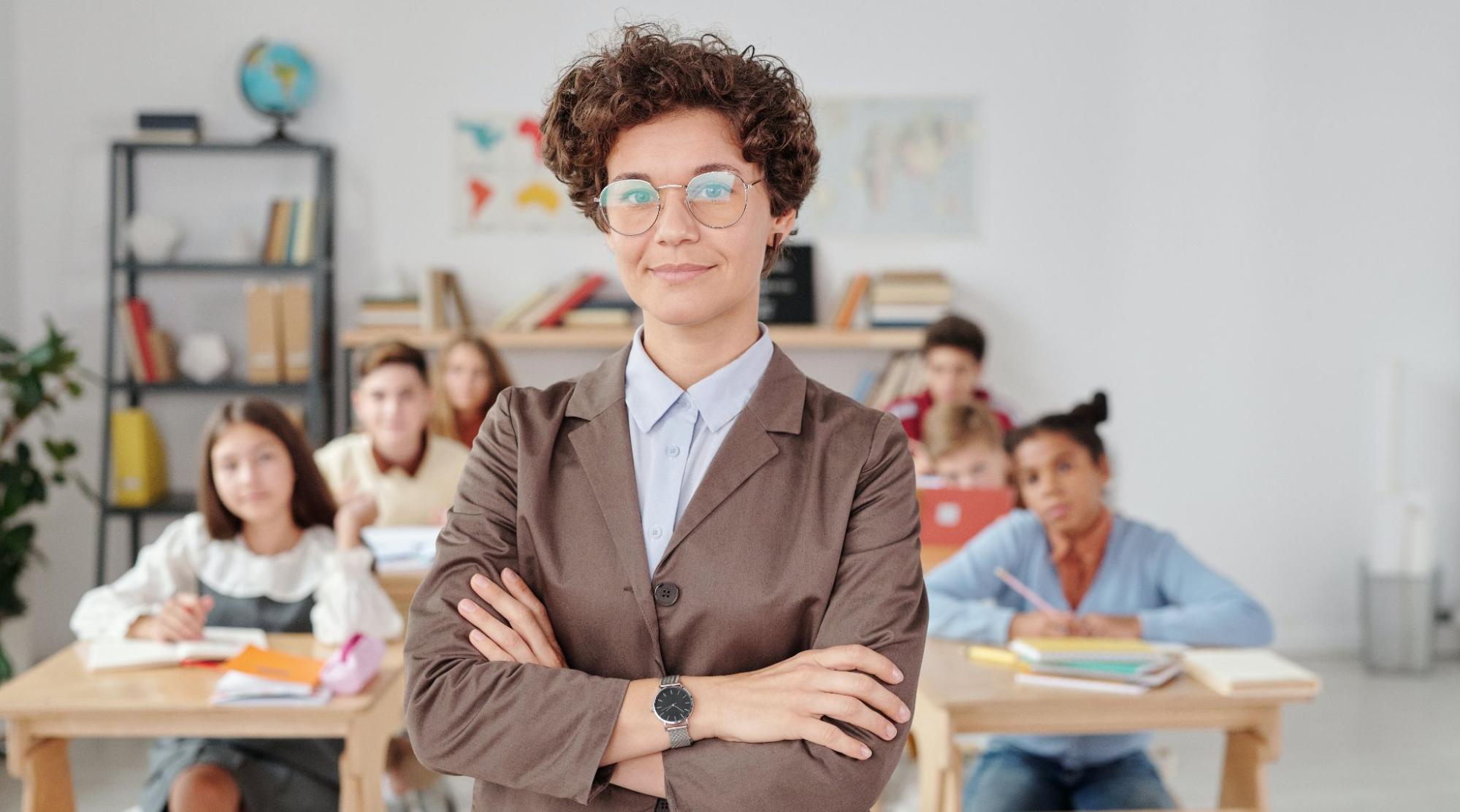 Teacher standing with arms crossed in front of class
