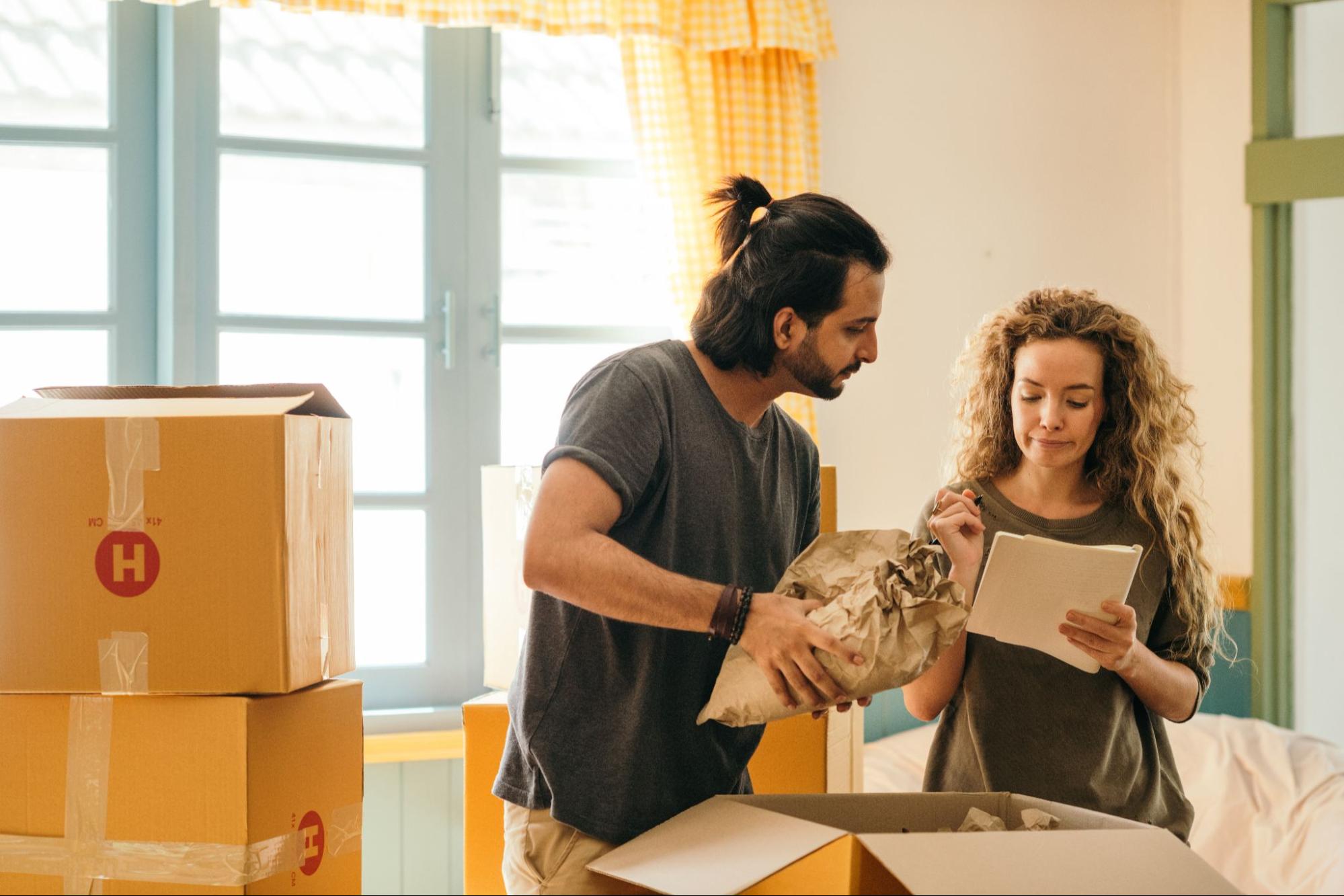 People packing boxes and checking moving list