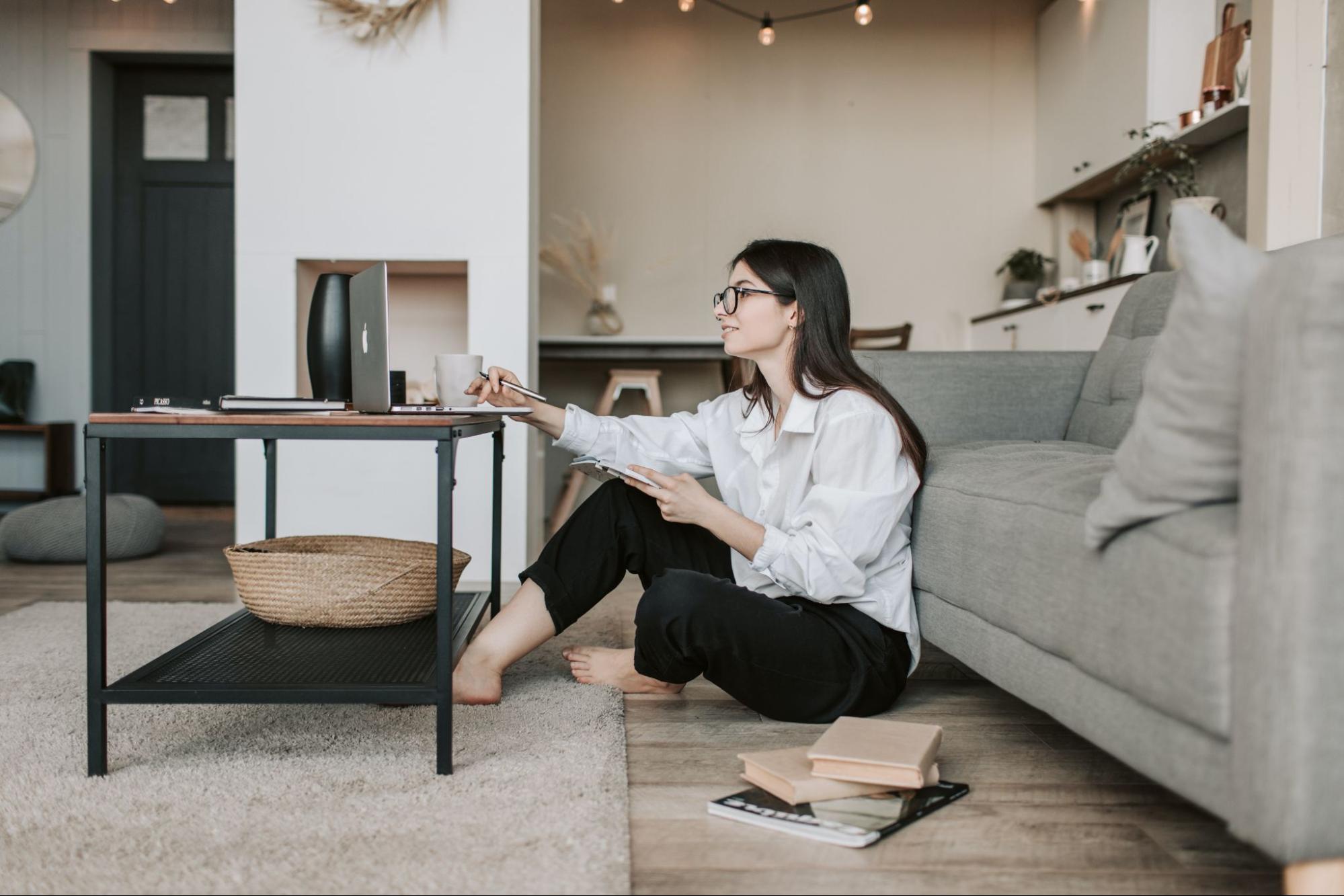 Woman working on laptop while sitting on the floor