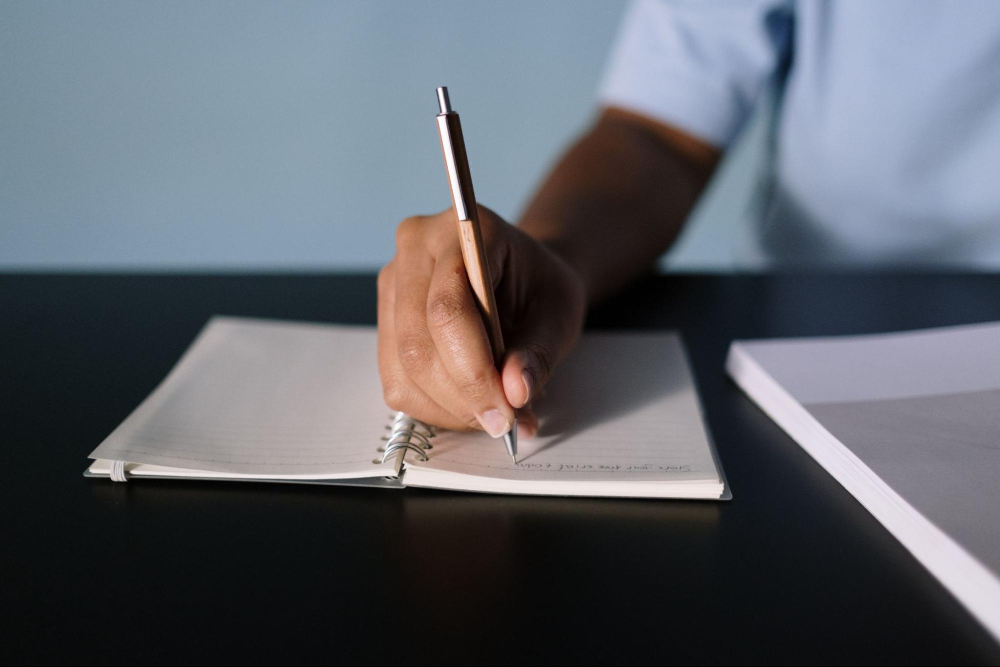 Person writing with pen on paper