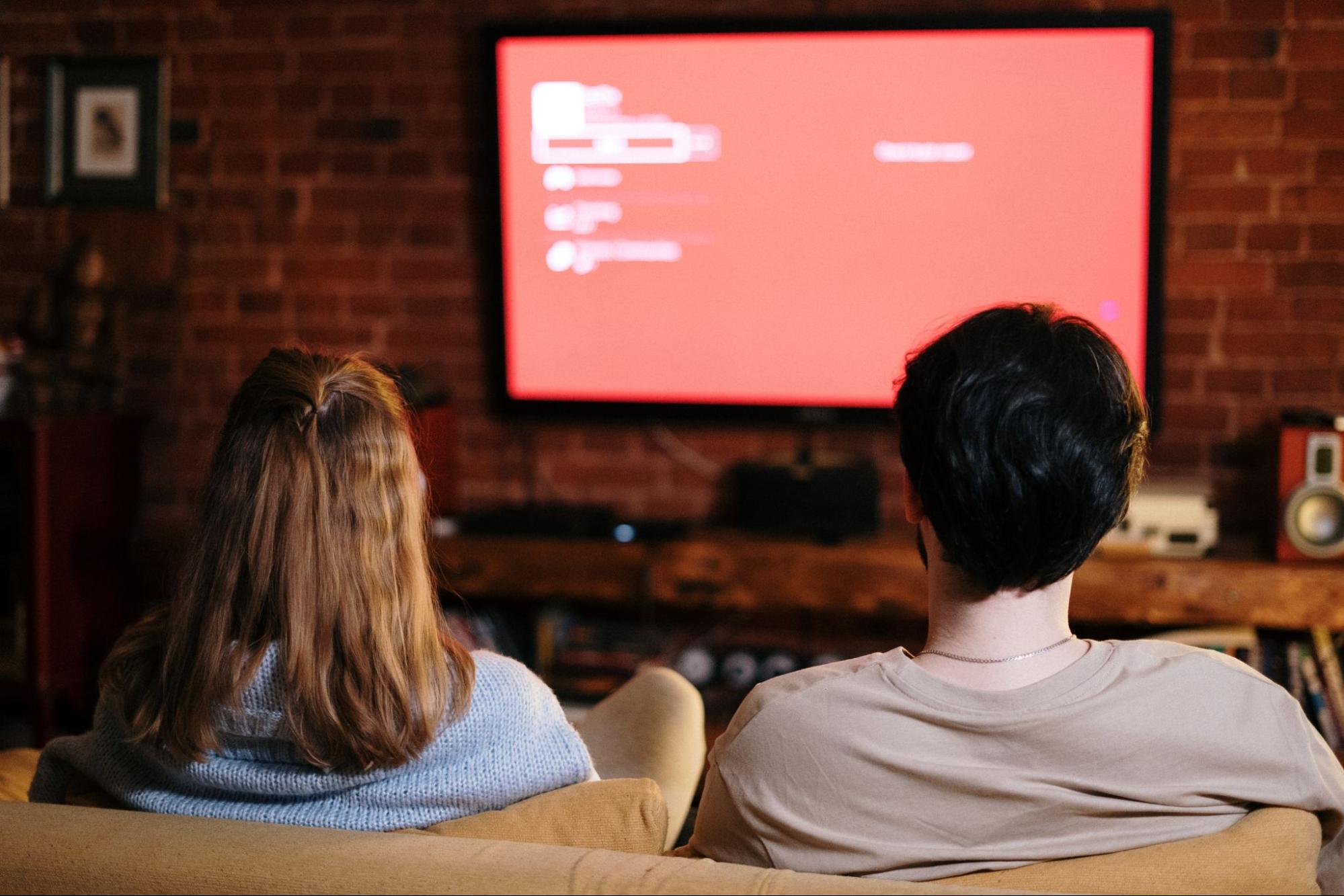 People sitting on couch watching TV