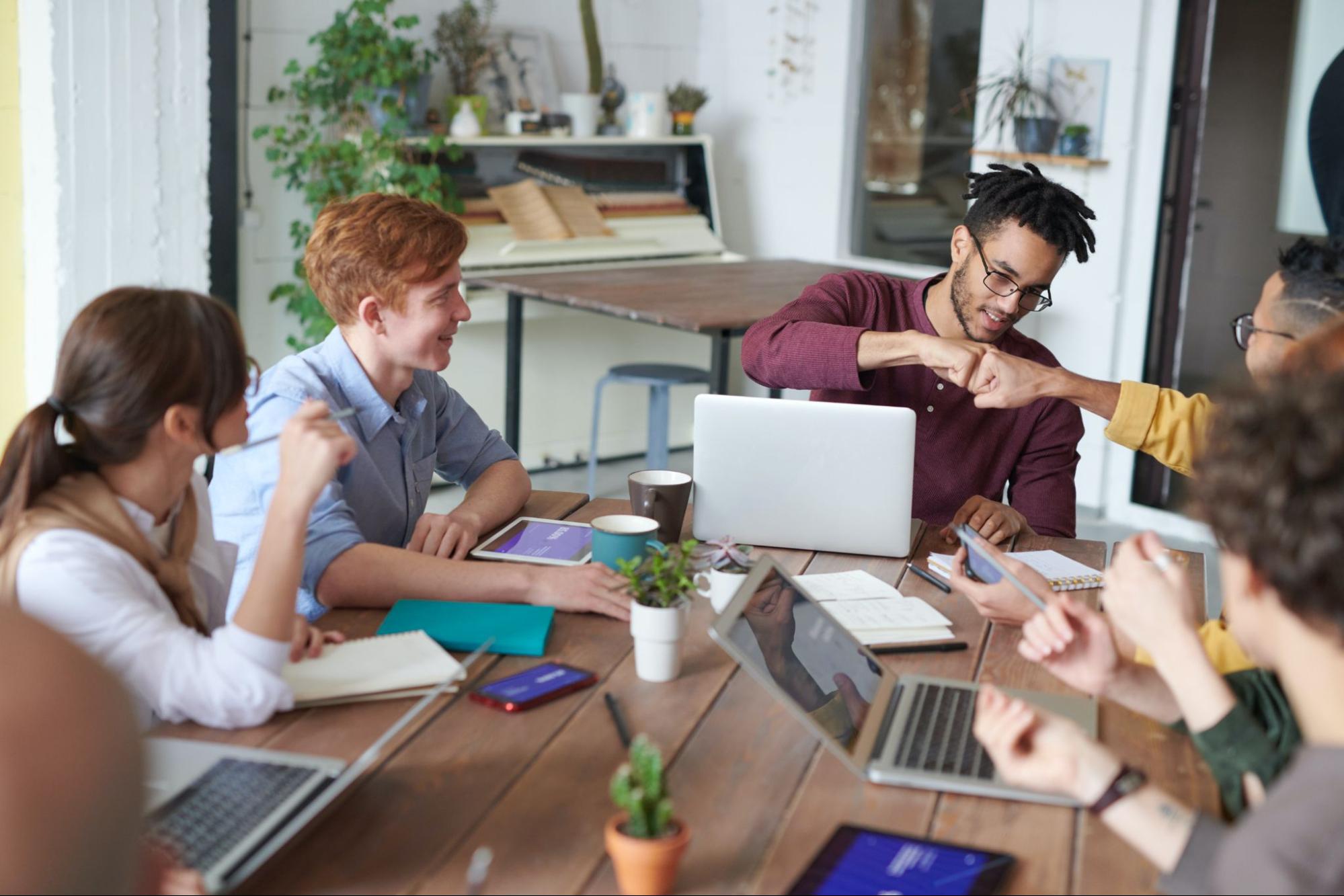 Employees interacting together at meeting table