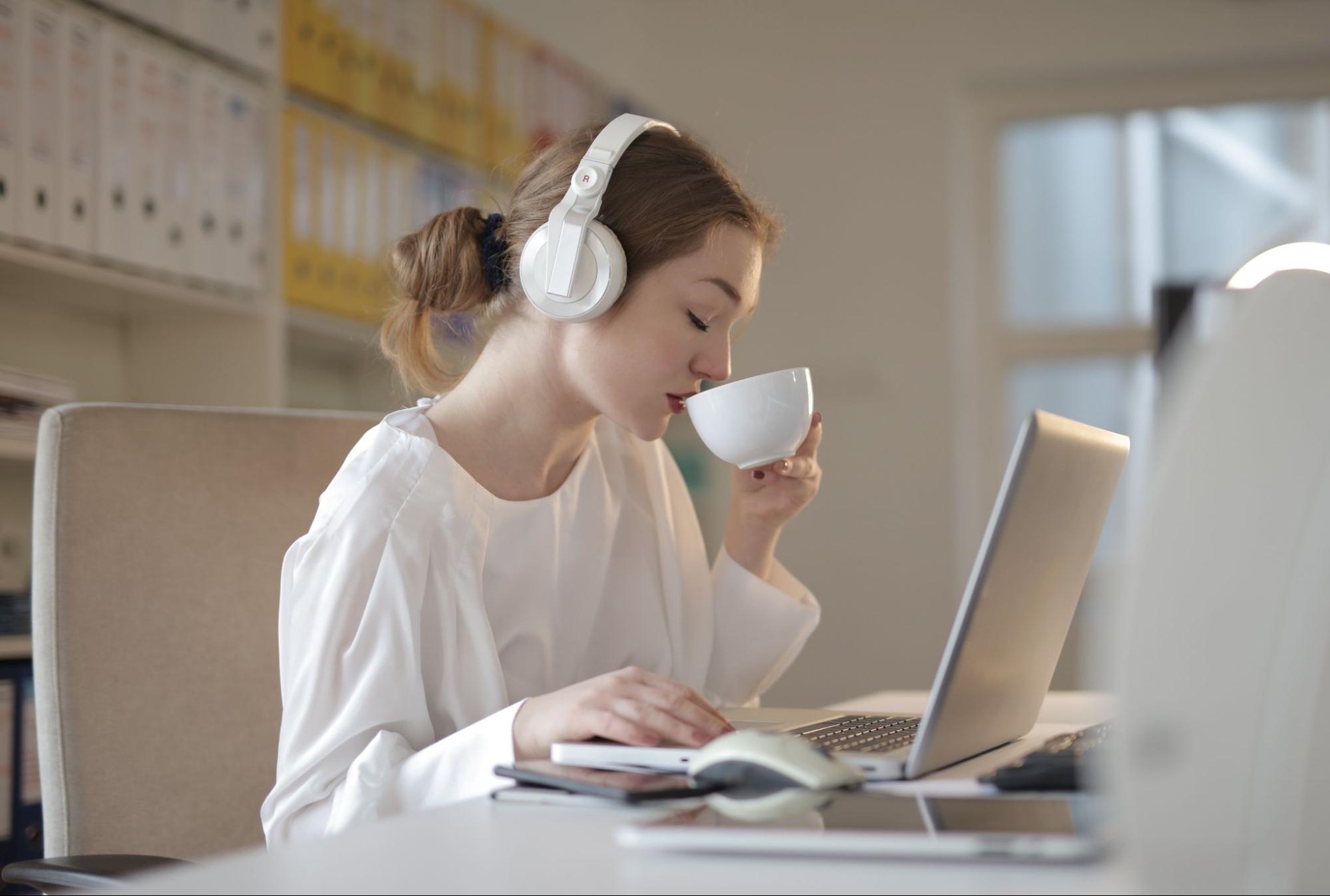 Person wearing headphones drinking coffee