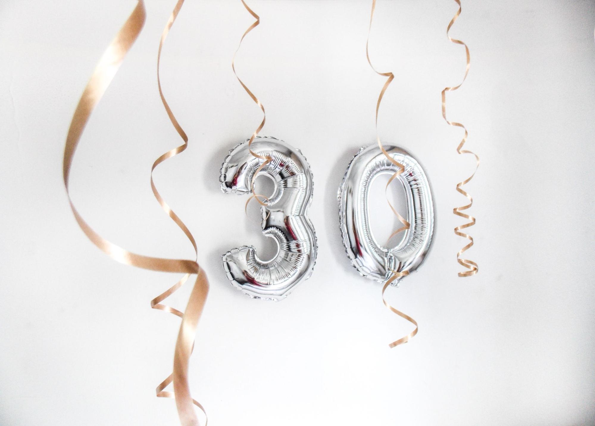 Silver balloons and streamers spelling 30