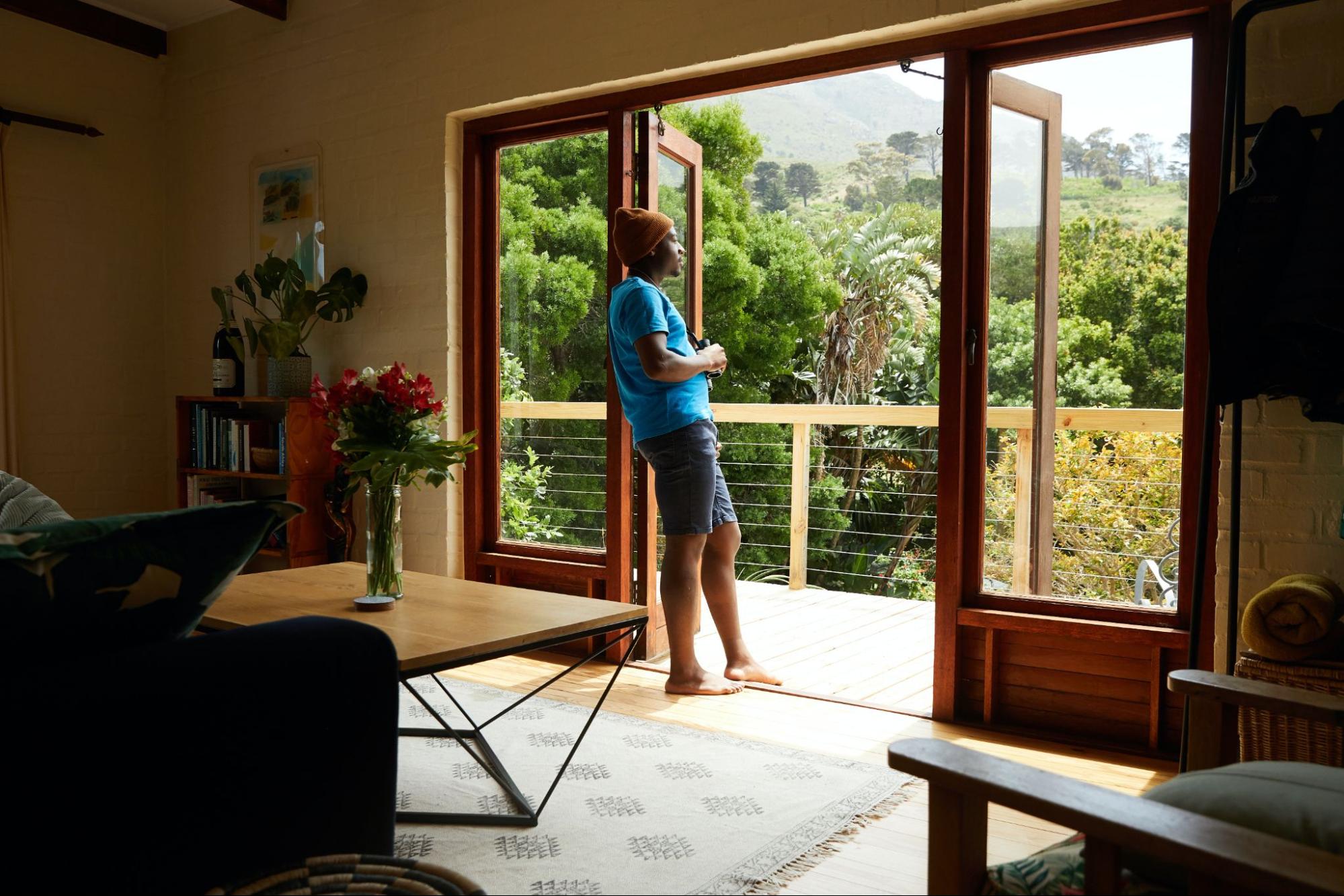Person in vacation house looking out window