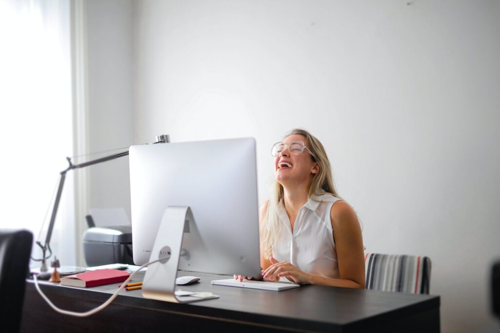 Person laughing in front of her computer