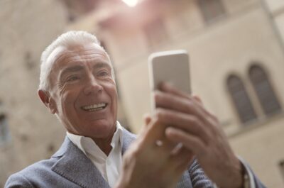 Older man laughing at something on his phone