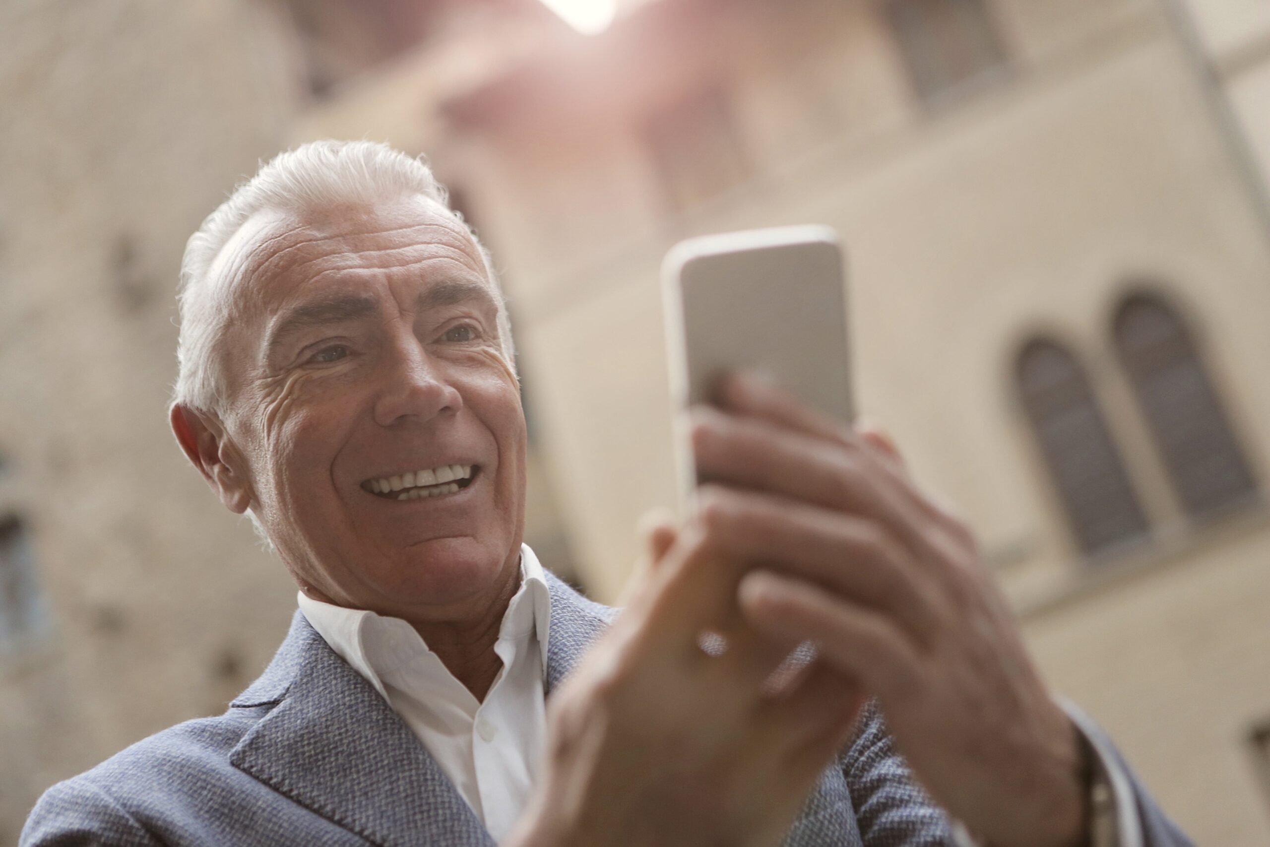 Older man laughing at something on his phone