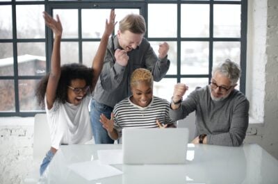 People celebrating in front of laptop