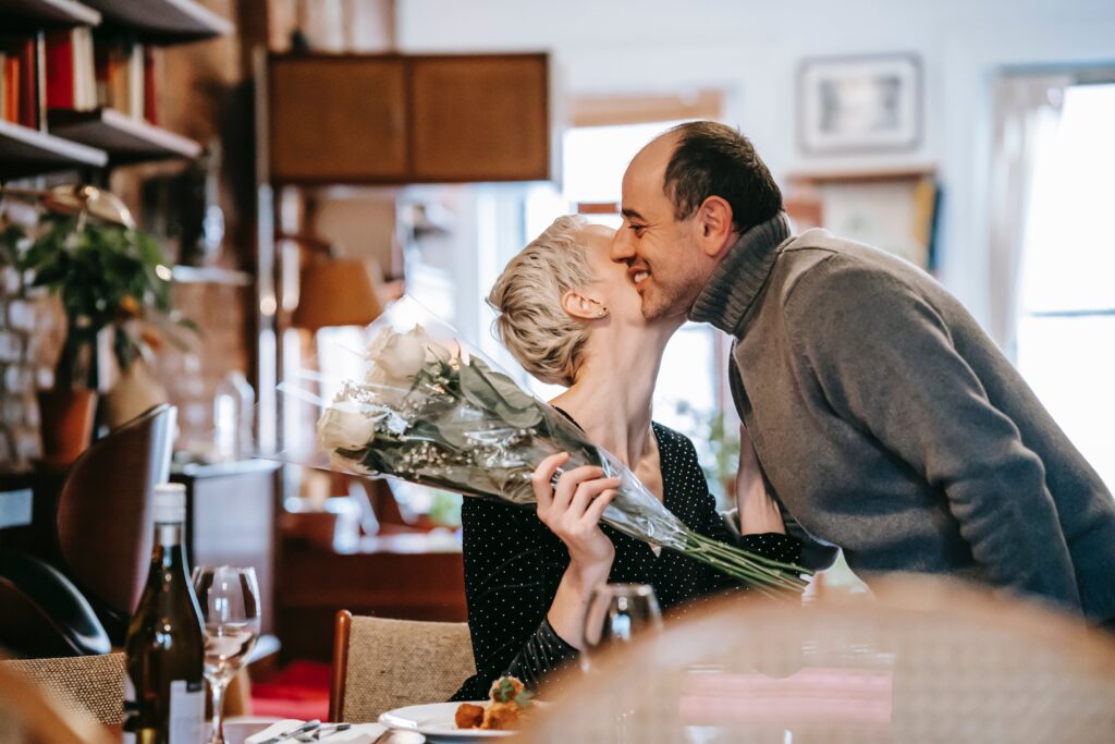 Person getting flowers and a kiss on the cheek