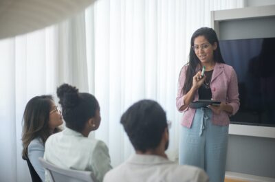 Meeting room where person is leading three employees through onboarding