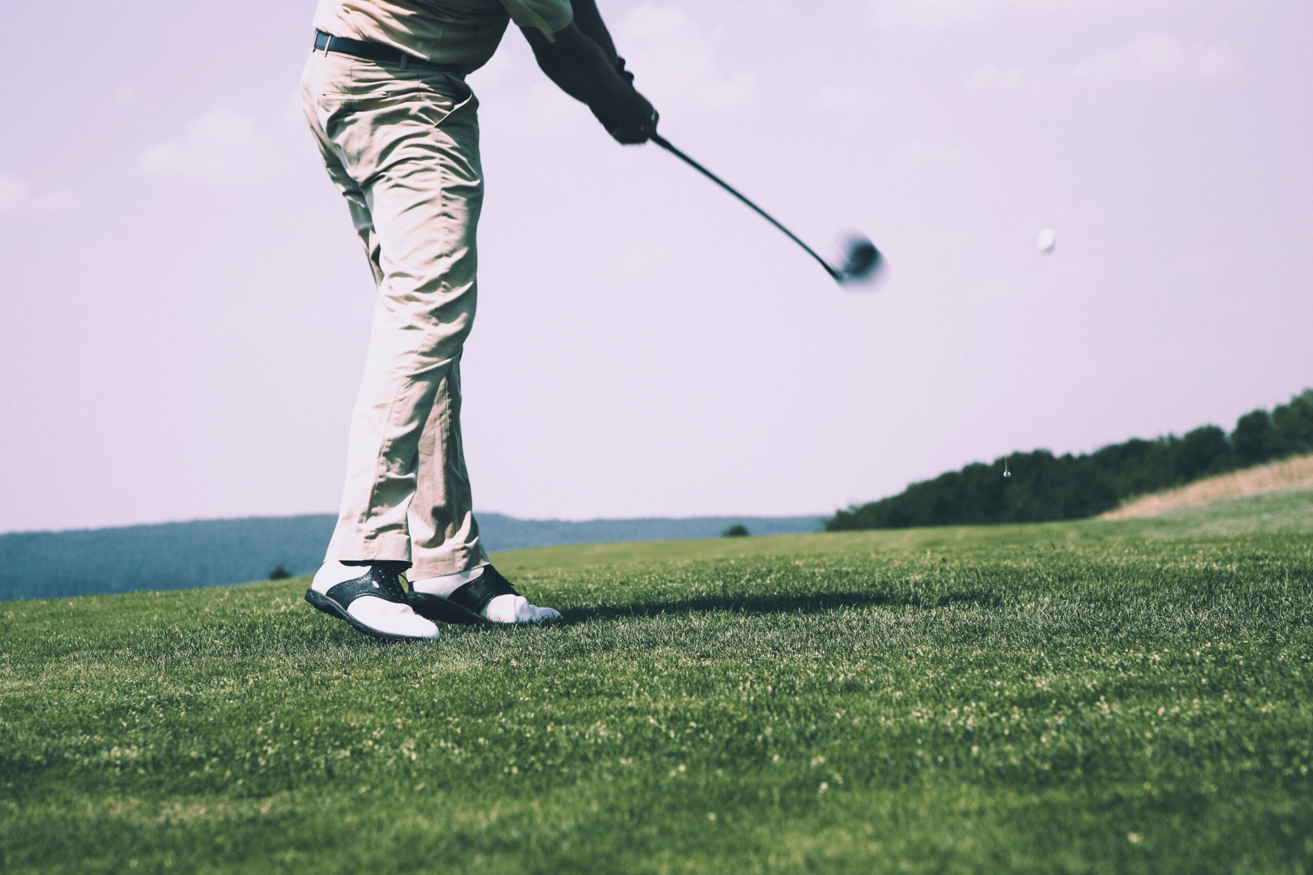 Person hitting a drive on golf course