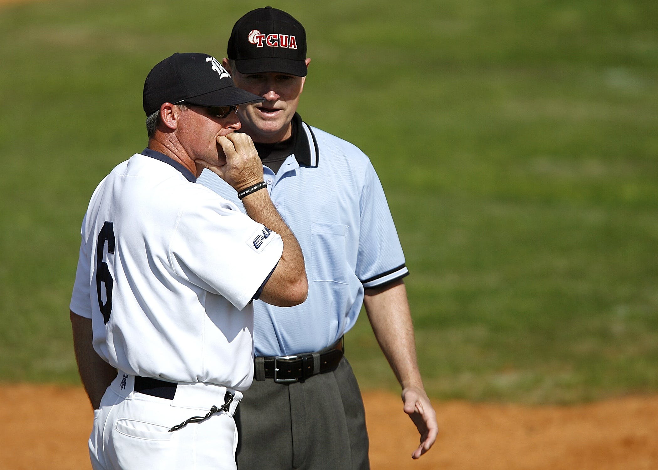 Baseball coach and umpire talking on the field
