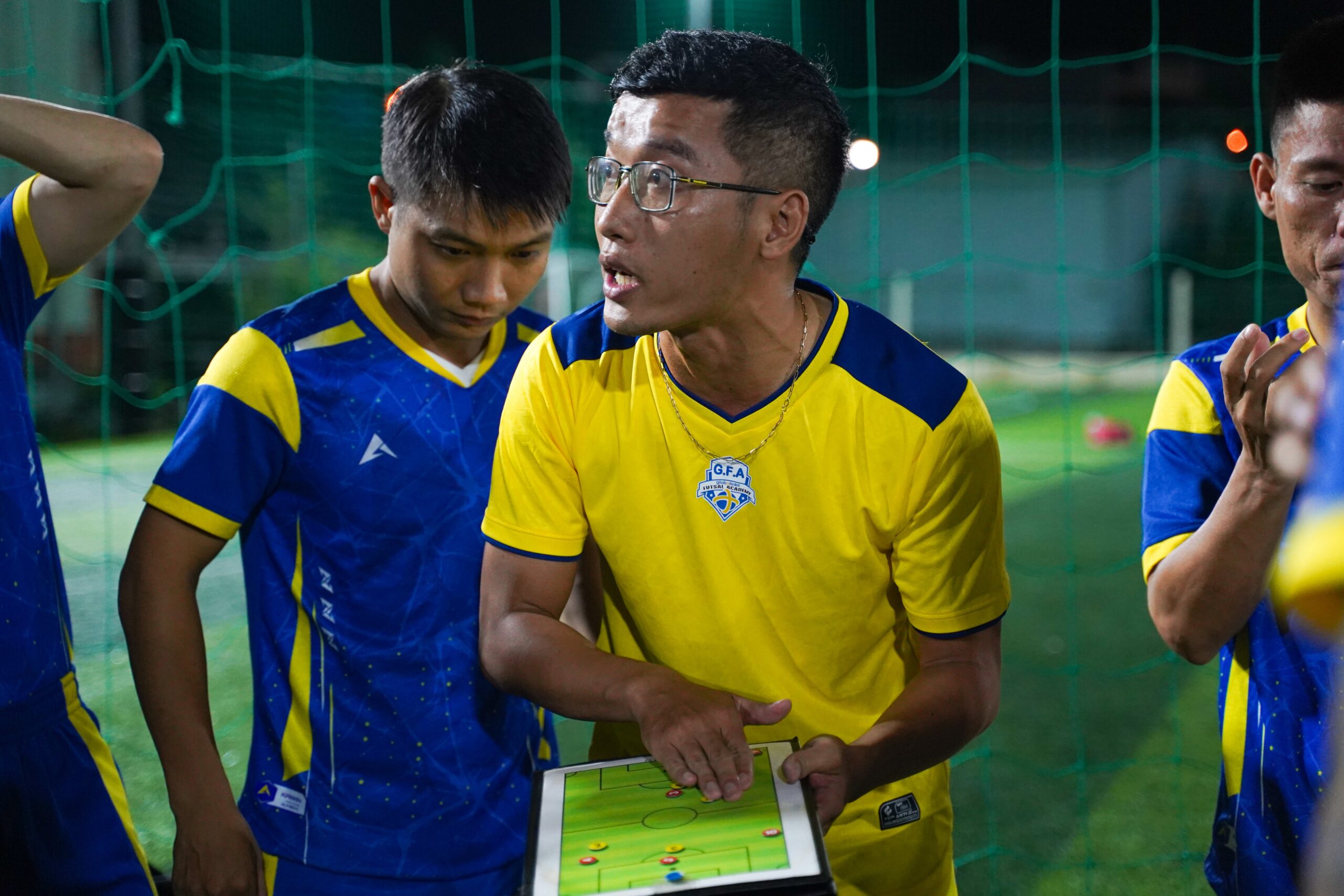 Man giving speech to Soccer players with clipboard