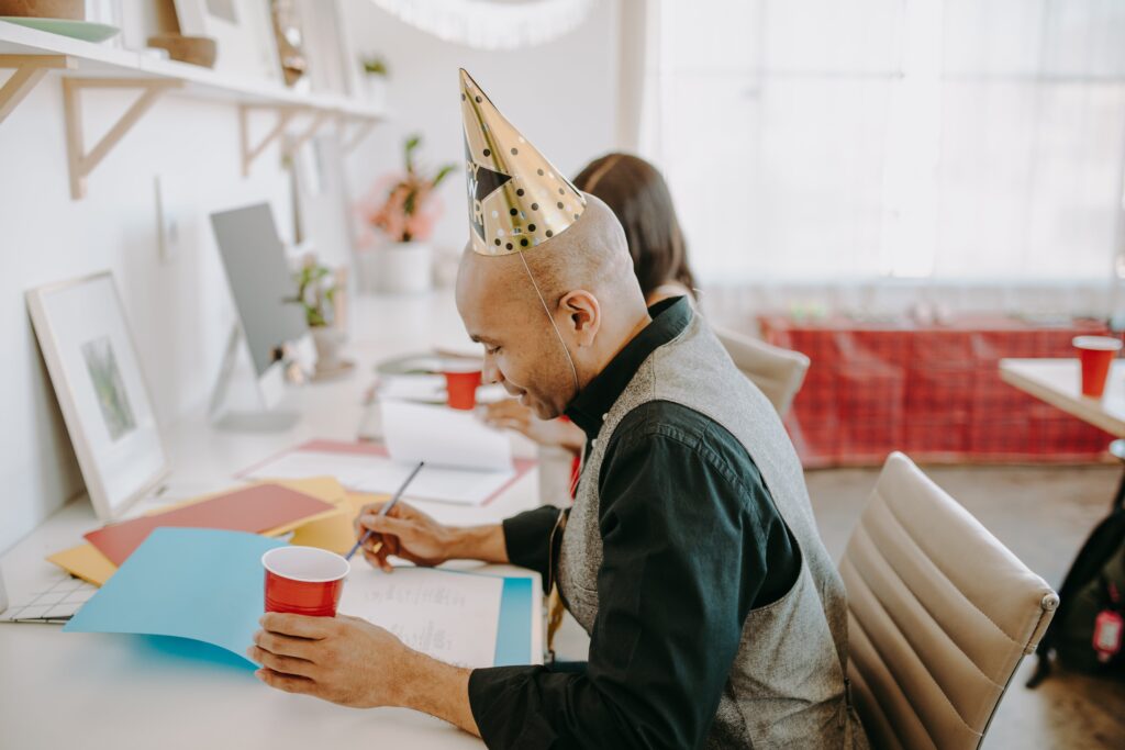 Office worker wearing party hat at desk