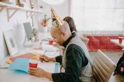 Office worker wearing party hat at desk