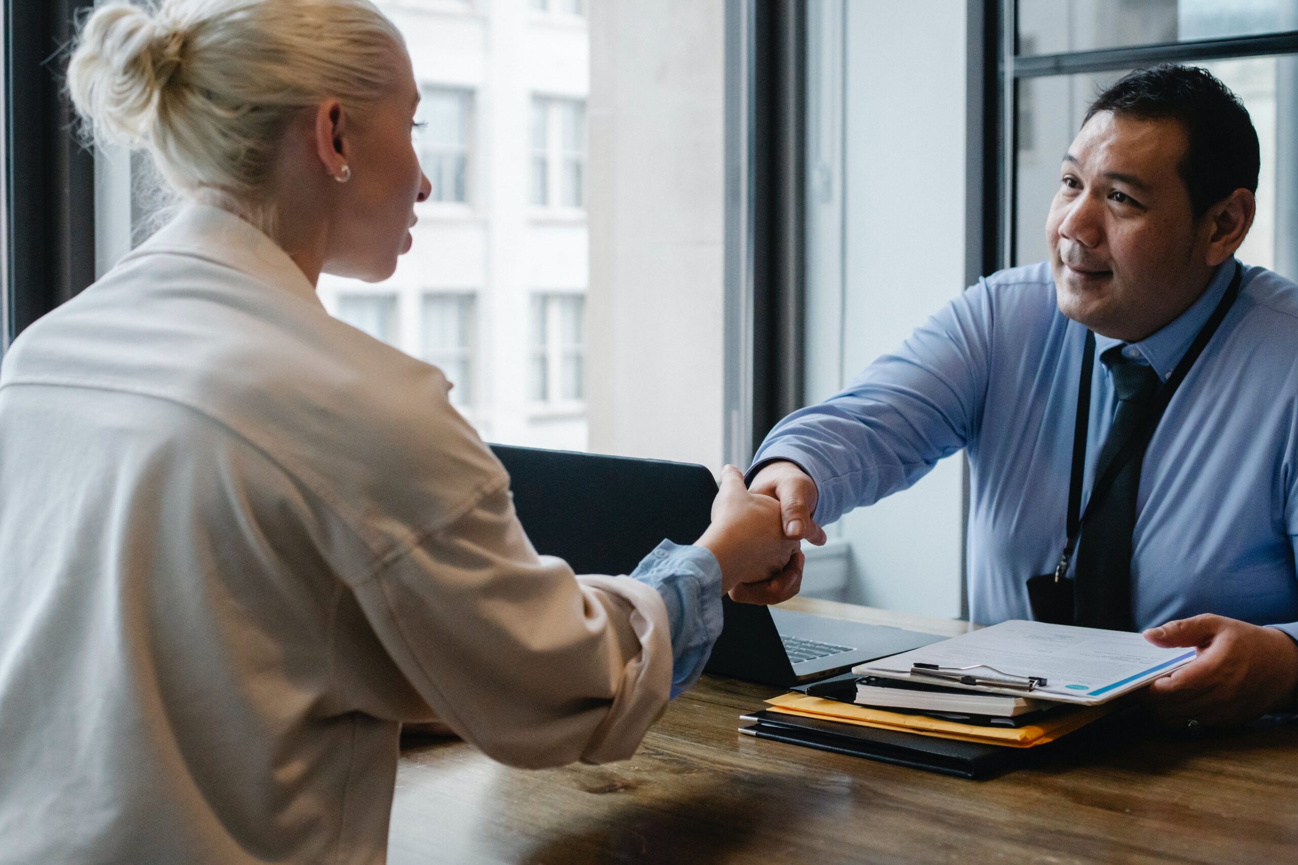 Boss sitting behind desk talking with employee