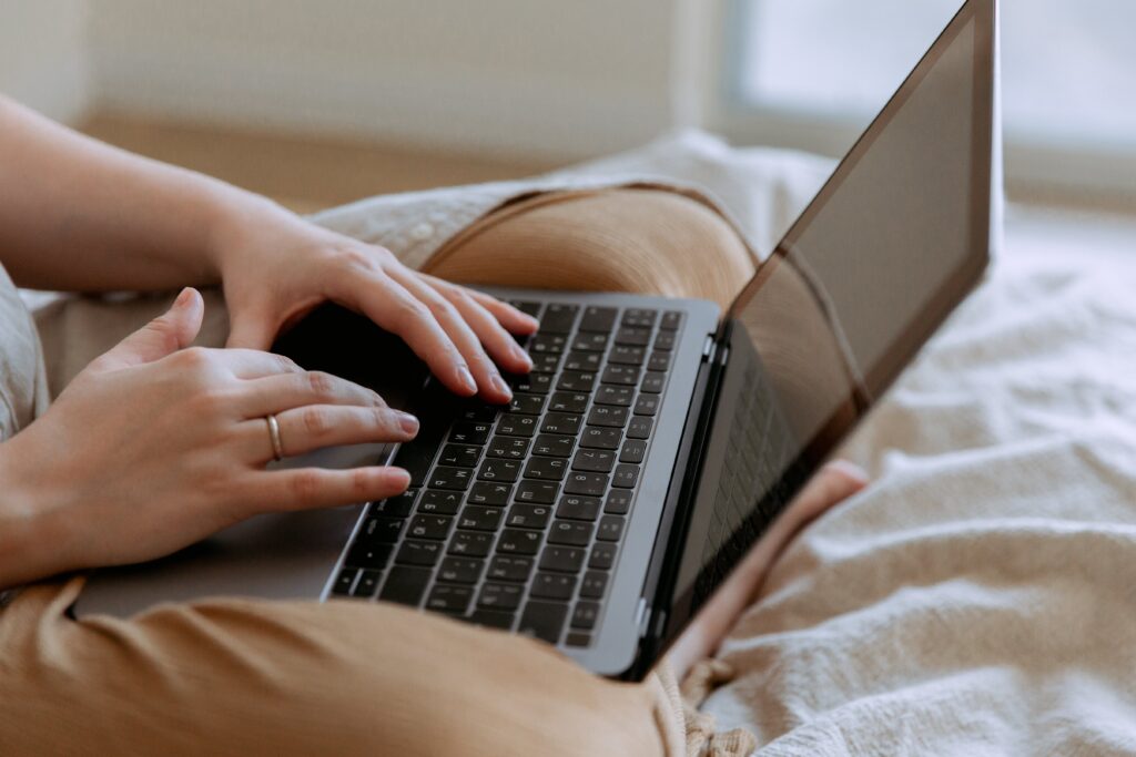 Person typing on laptop in bed