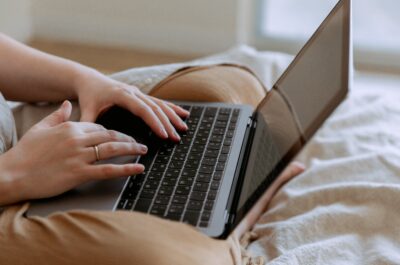 Person typing on laptop in bed