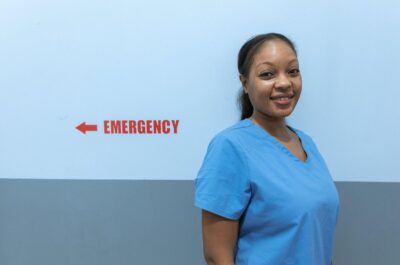 Smiling nnurse standing in hallway