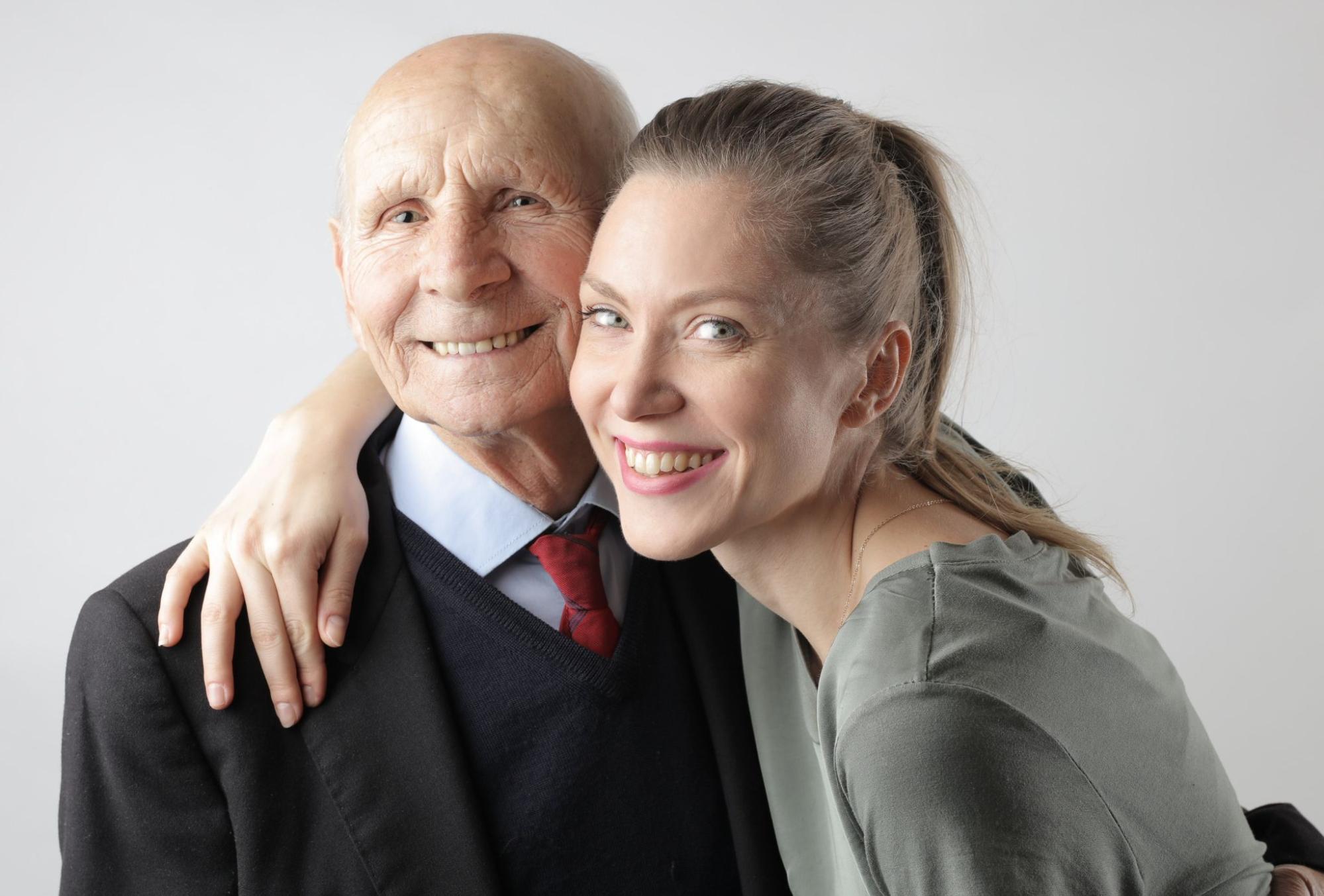 Father and daughter hugging and looking at camera