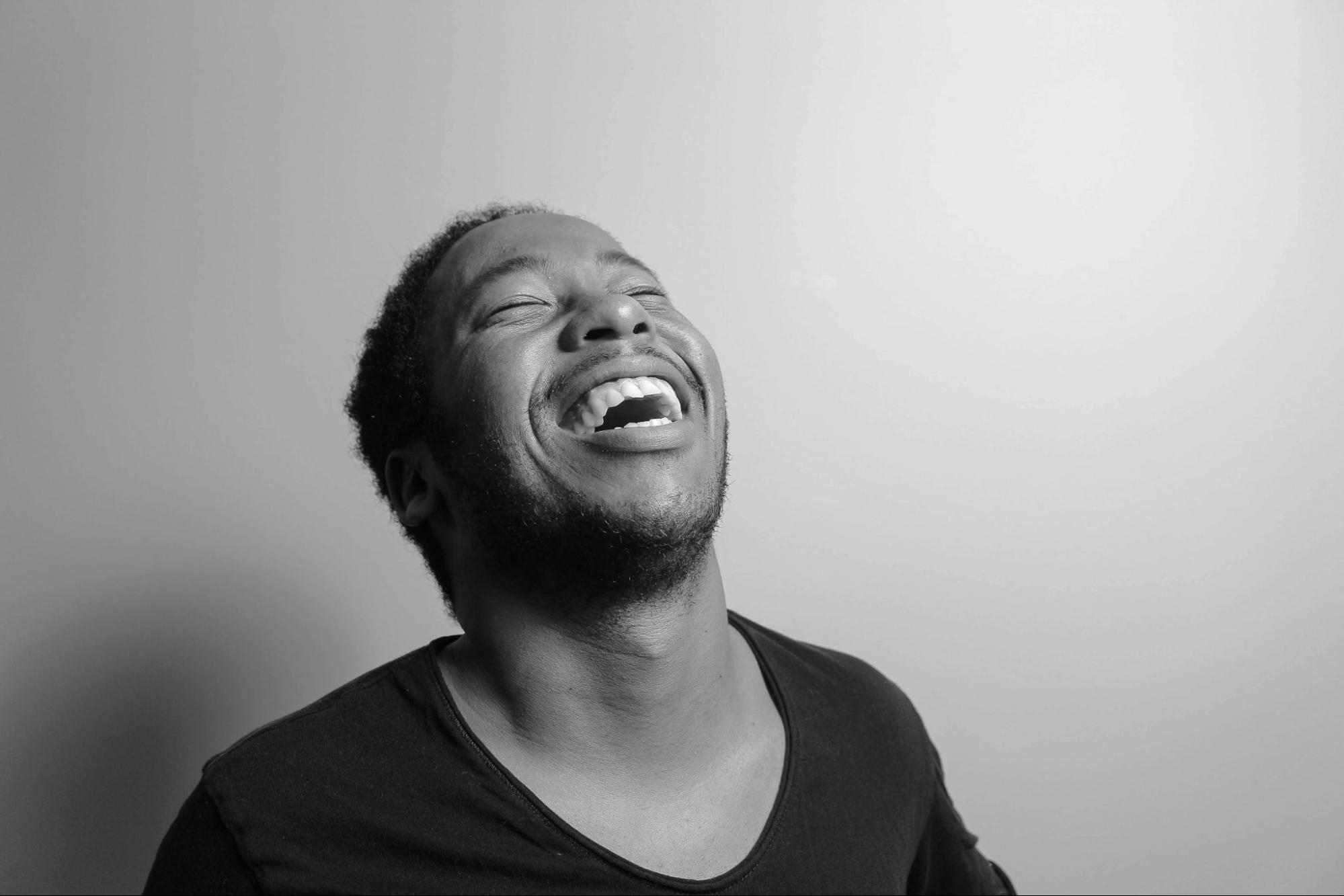 Man laughing out in black and grey room