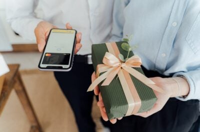Gift and person with credit card on phone