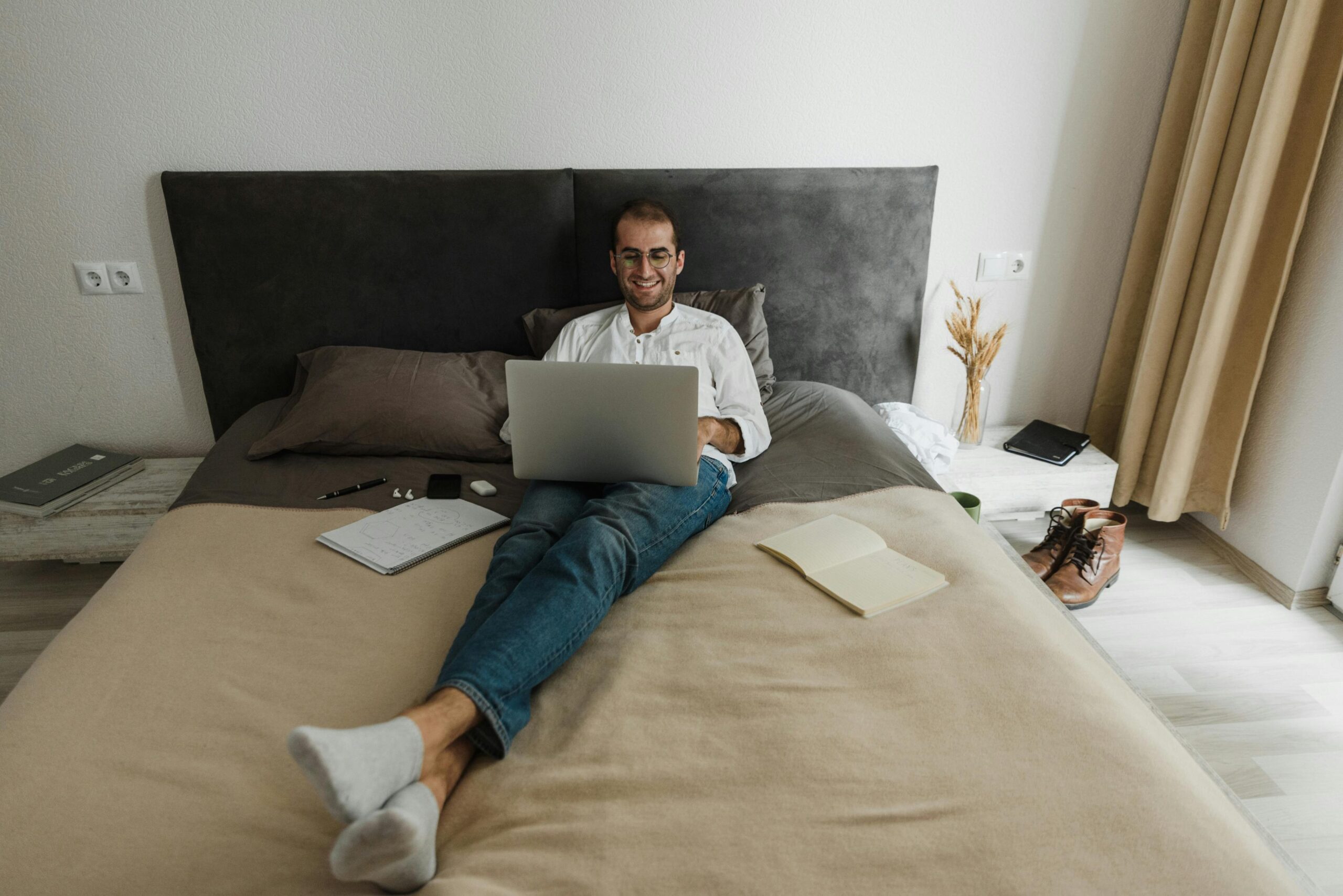 Man using laptop in bed to send email