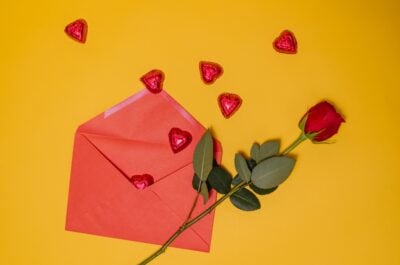 Valentine's Day rose and envelope against yellow background