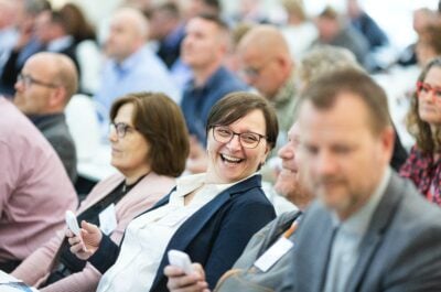 Employee laughing in crowded room of people