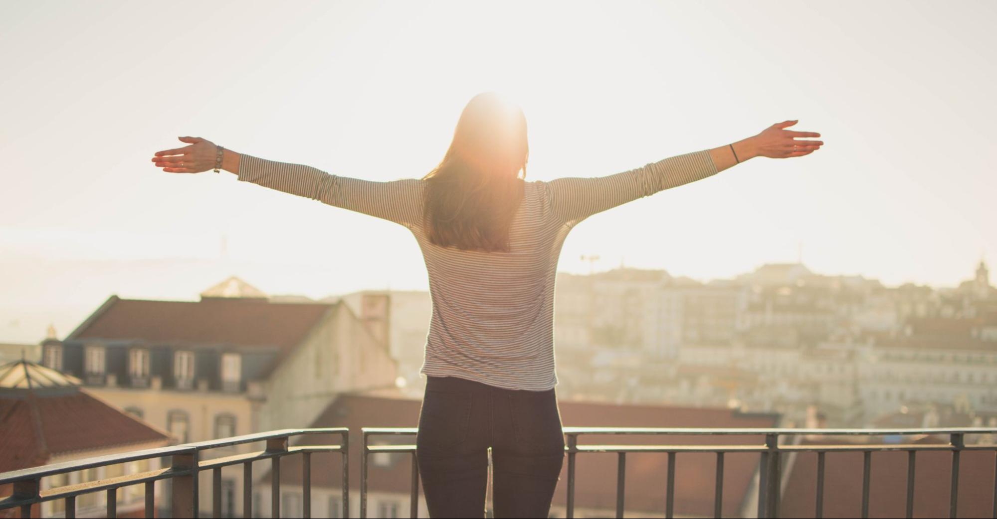 Employee outside in the sunshine with arms outstretched