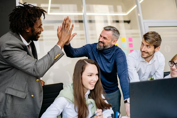 Employees high fiving together in the office