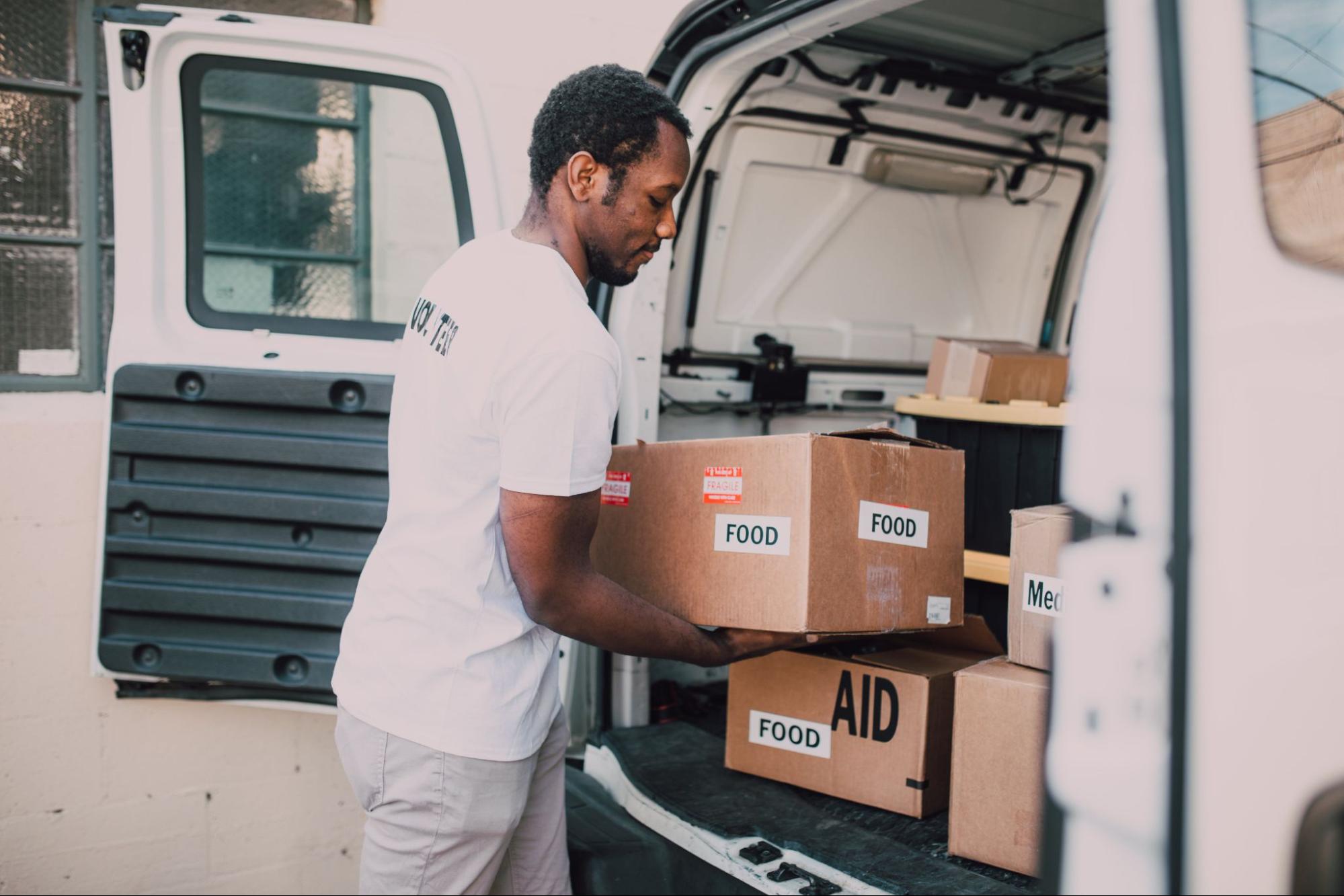 Employee volunteer unloading food from van