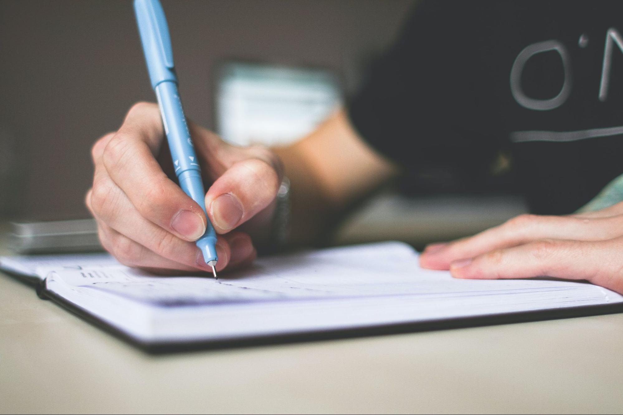 Person writing notes in a journal