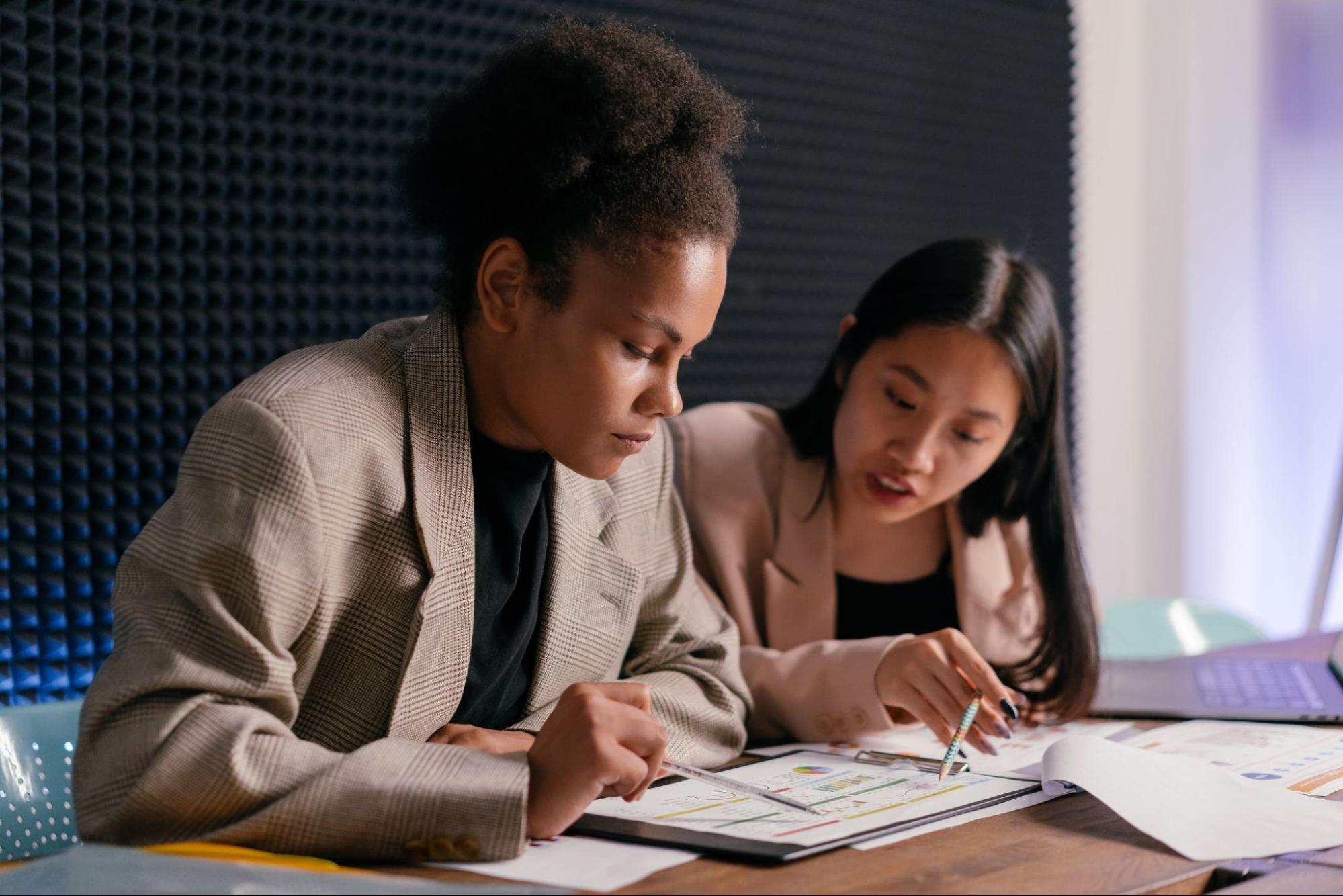 Two coworkers going over documents at desk