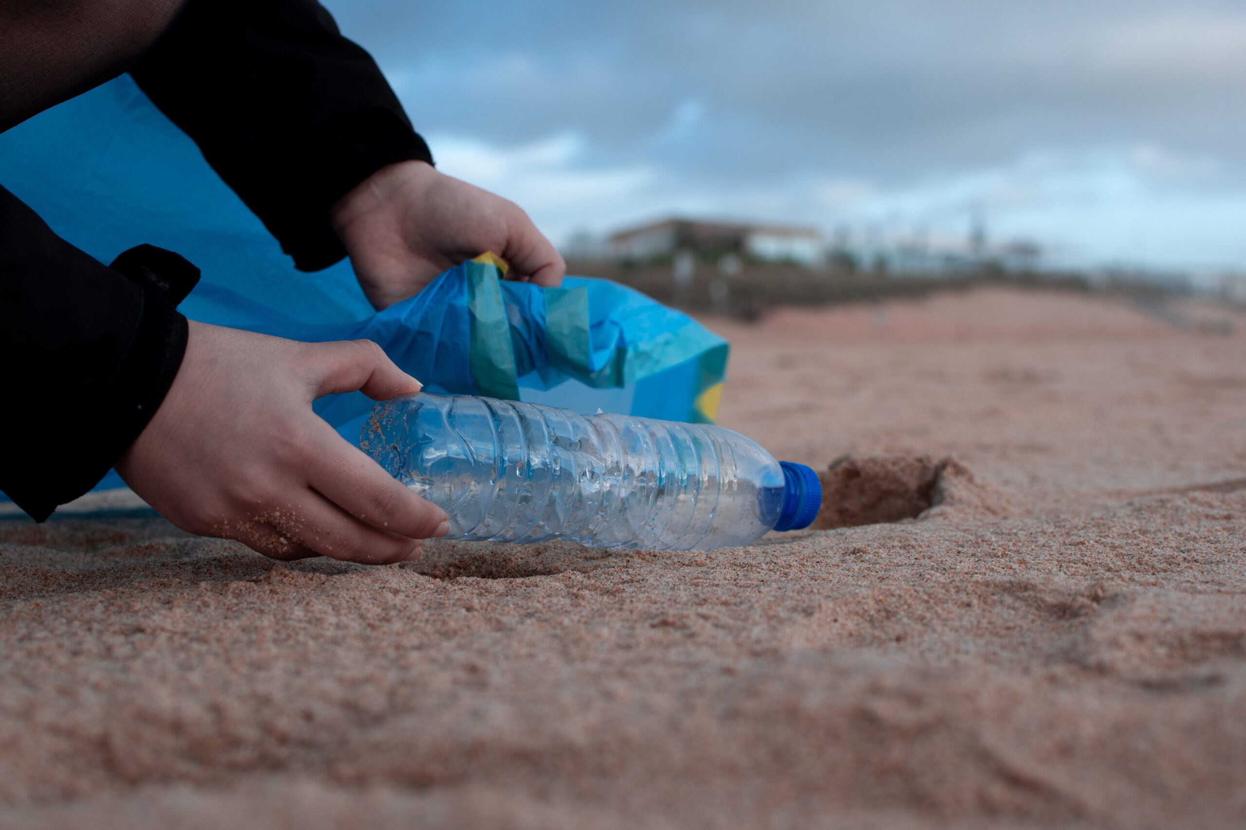 Person picking up trash on beach during volunteer day