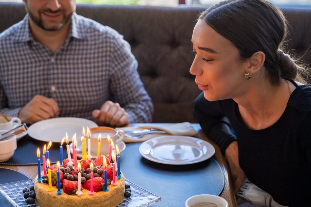 Friend blowing out candles on a birthday cake