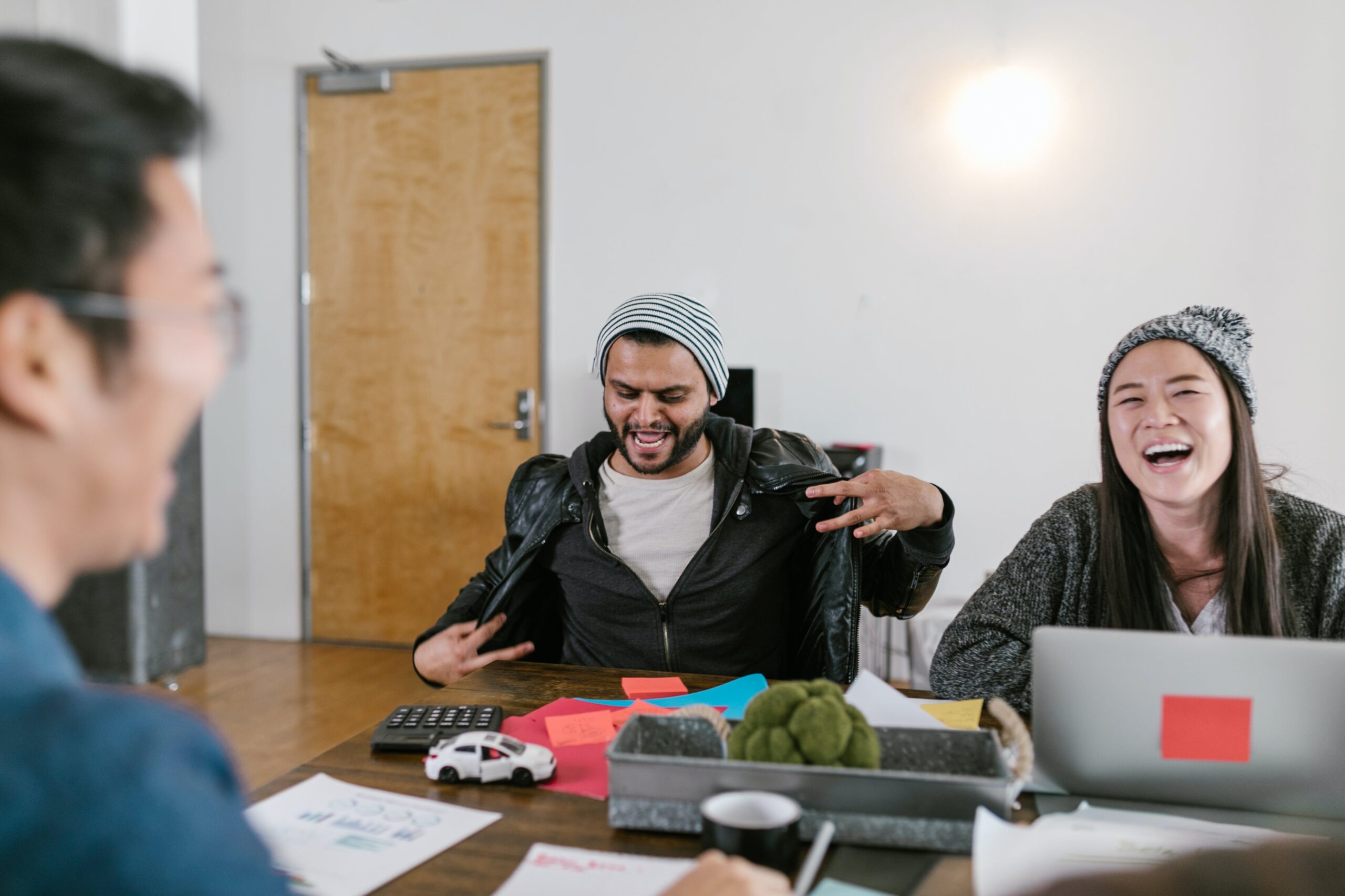 Employee making a funny gesture and laughing with team members