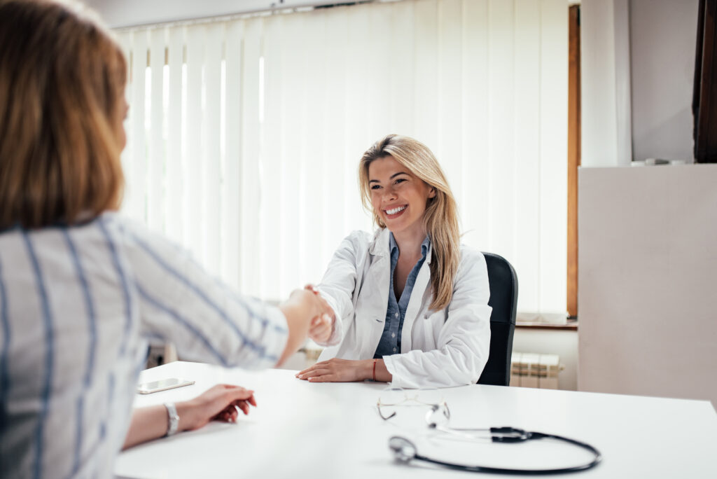 Younger doctor shaking hands with patient