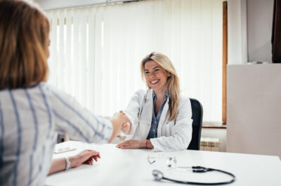 Younger doctor shaking hands with patient