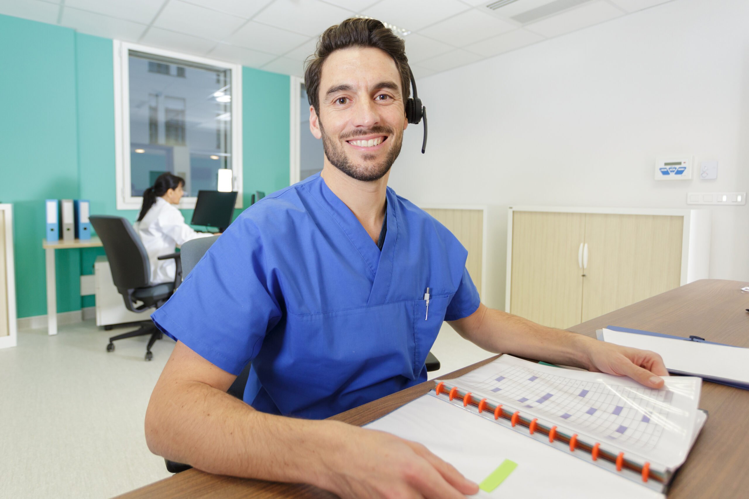 Male administrative professional in scrubs with calendar