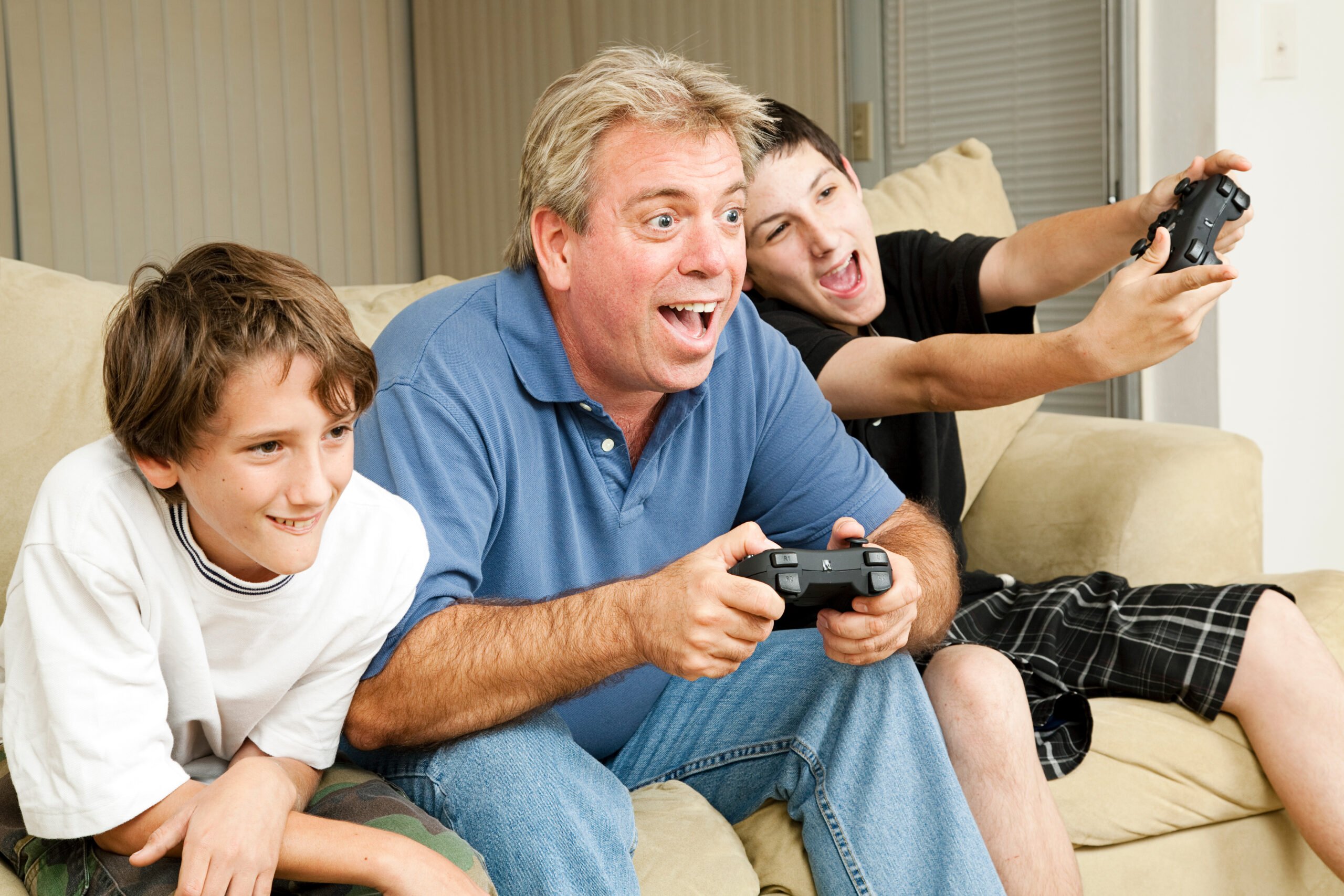 Uncle playing video games with kids on couch