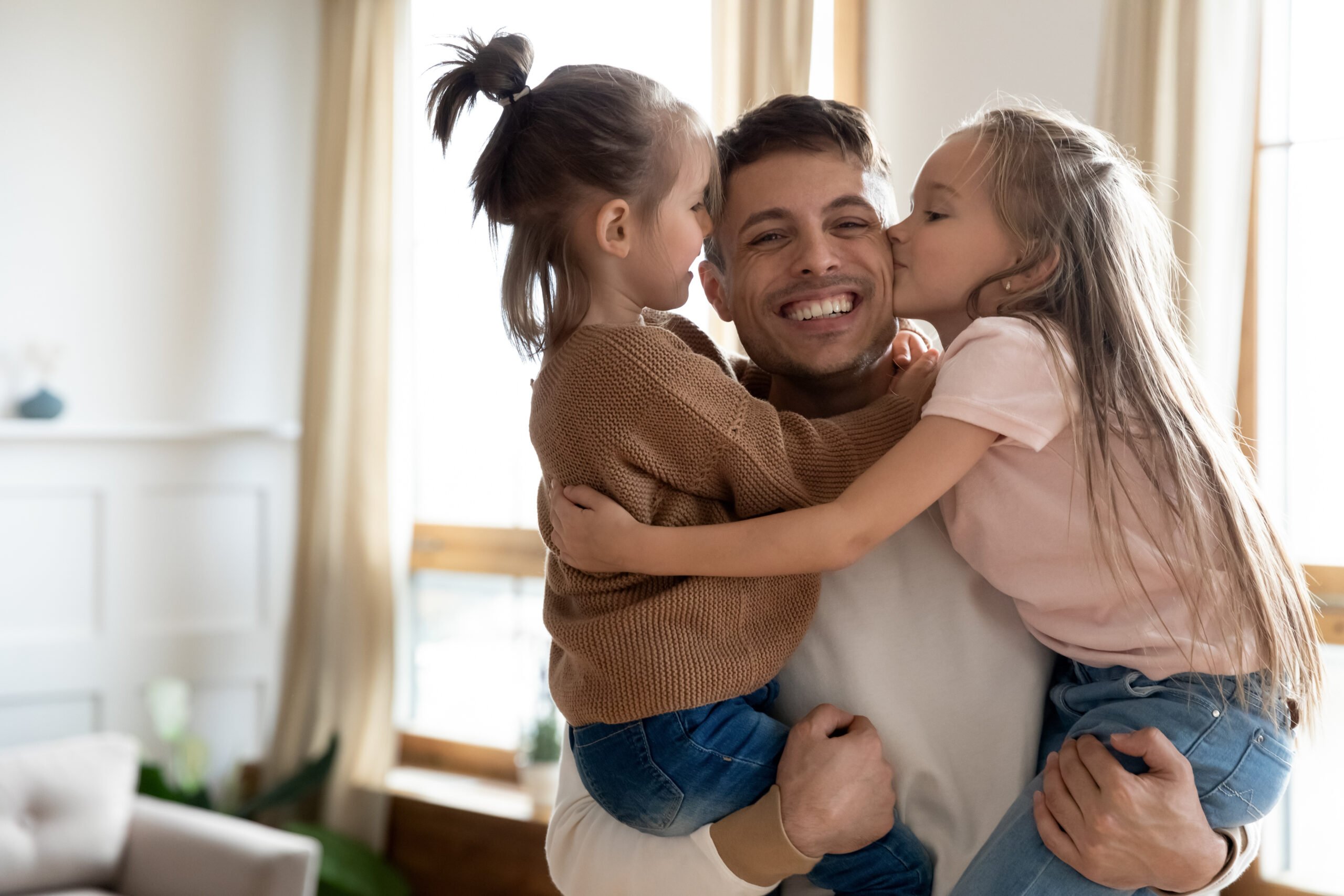 Uncle holding two nieces in arms