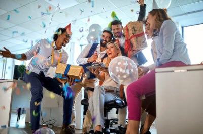 Woman celebrating office birthday with other employees