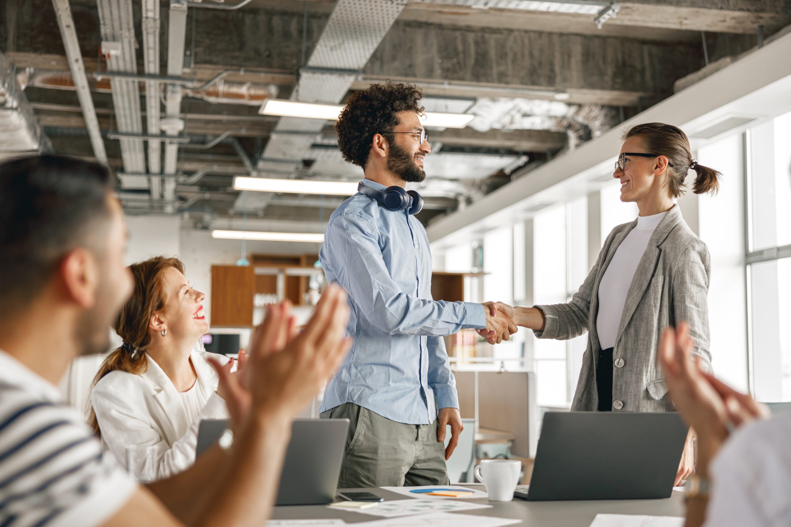 Boss shaking hands with new employee to say 