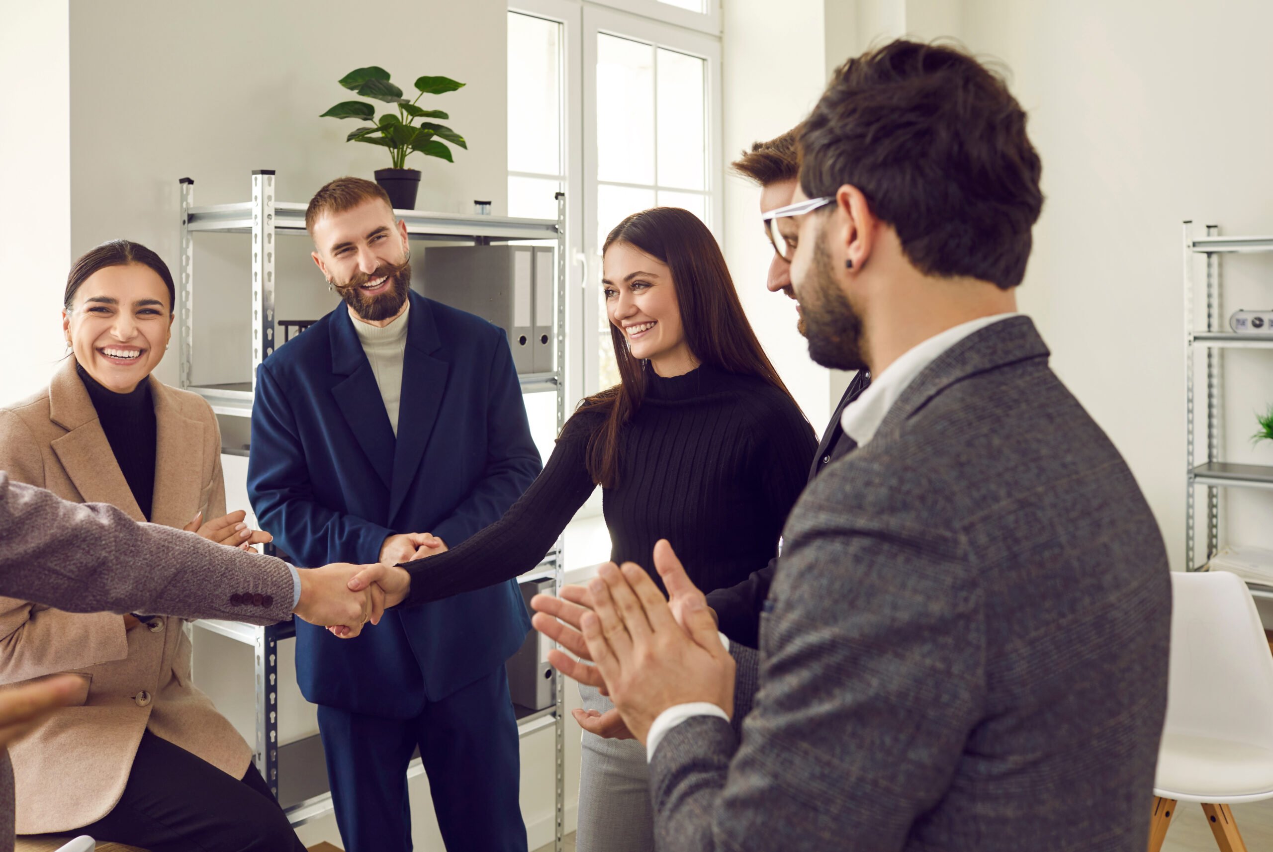Employee shaking hand with new coworkers during welcome to the team event